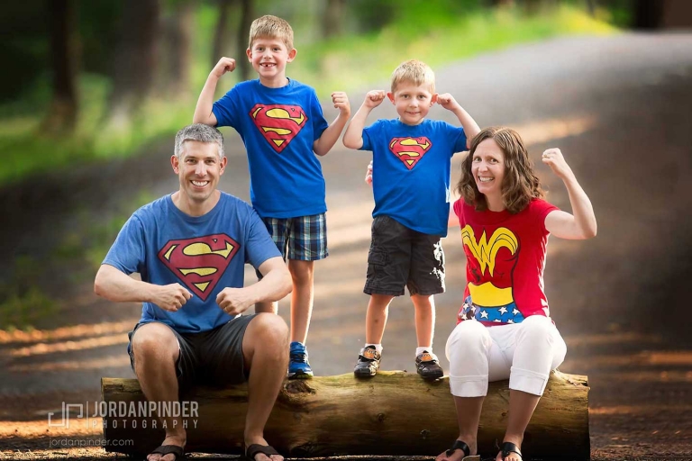 Four people flexing on log during family photography session