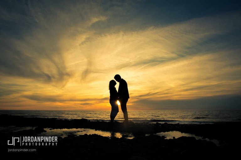 silhouette of engaged couple on the beach at sunset