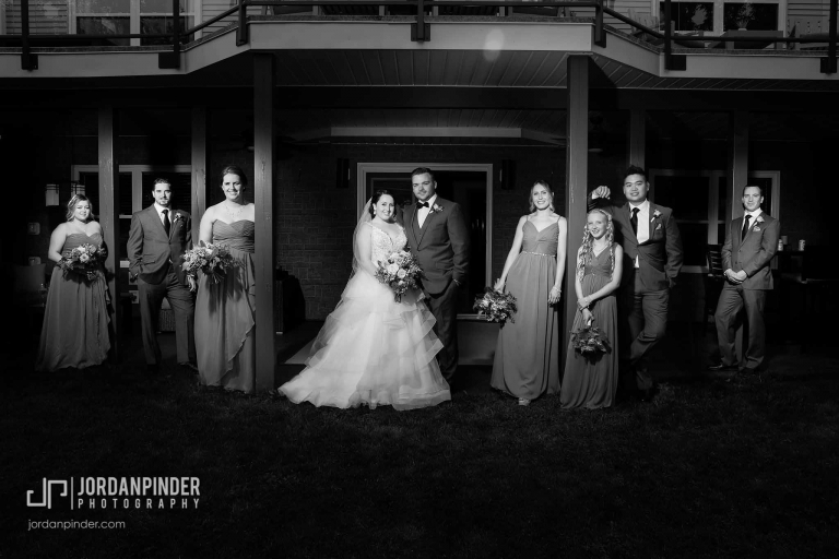 wedding party standing casually in front of house