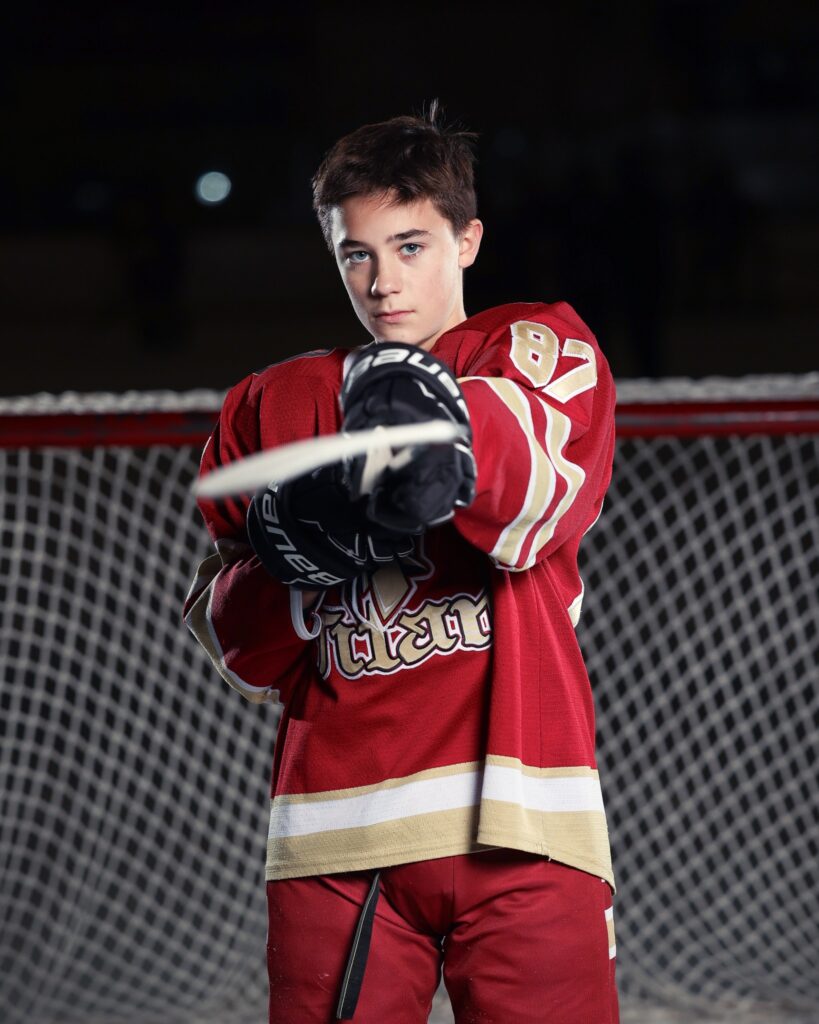 hockey player pointing stick at camera