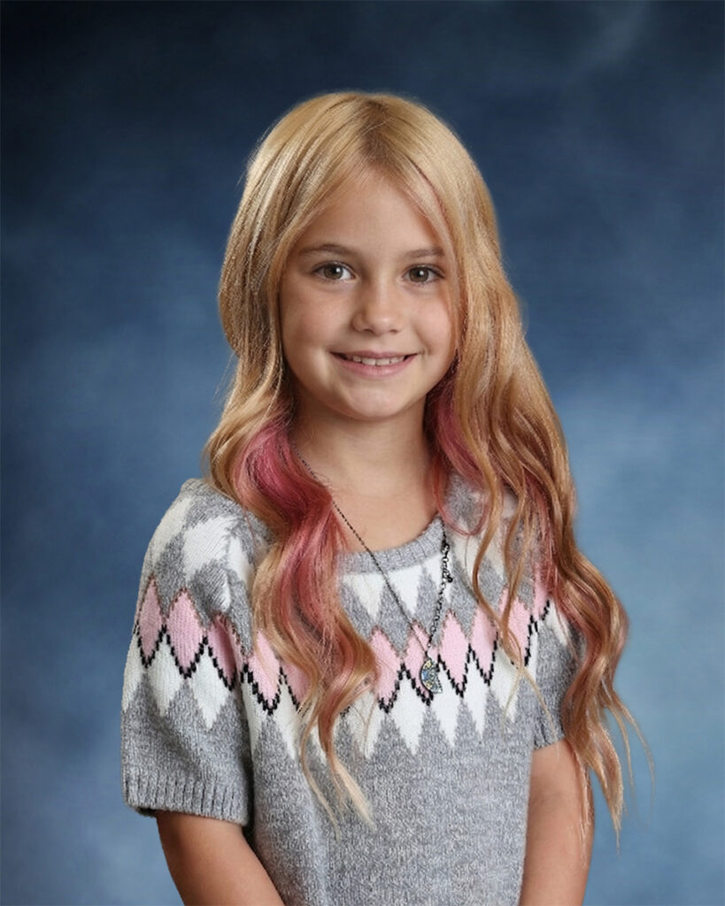 girl with long blond and pink hair posing for school picture day